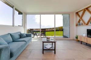 a living room with a blue couch and a table at Casas do Forneiro - T2 in Nordeste