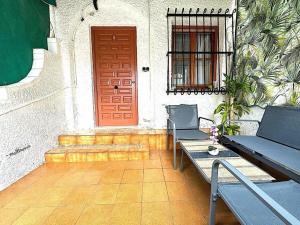 a patio with two benches and a red door at Casita de Lucia in Santa Pola