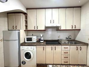a kitchen with a white refrigerator and a microwave at Casita de Lucia in Santa Pola