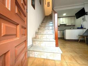 a staircase in a room with a door and a kitchen at Casita de Lucia in Santa Pola