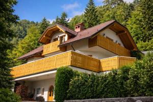 a house with wooden balconies on top of it at Apartment Milly in Bled