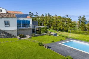 a backyard with a swimming pool and a house at Casas do Forneiro - T2 in Nordeste