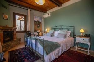 ein Schlafzimmer mit Bett und Kamin in der Unterkunft Pandion Luxury Boutique Hotel & Suites with Spa in Neochóri