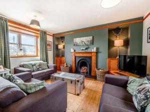 a living room with a couch and a fireplace at The Old Library, Brora in Brora