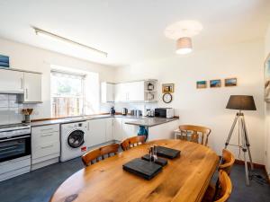 a kitchen with a wooden table and chairs in a room at The Old Library, Brora in Brora +8 photos