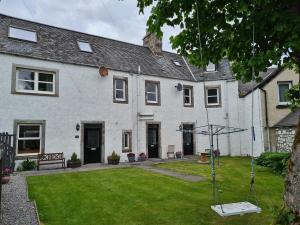 a house with a yard with a swing at The Old Library, Brora in Brora