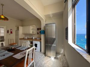 a kitchen with a table and a refrigerator at Panoramic XL Penthouse Sliema Seafront in Sliema