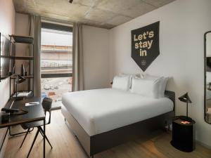 a bedroom with a bed and a desk with a sign on the wall at The Social Hub Rome in Rome