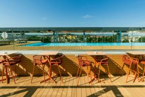 a patio with tables and chairs on a roof at The Social Hub Florence Belfiore in Florence