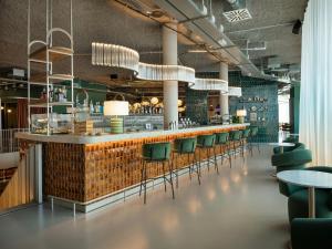 a bar in a restaurant with green chairs at The Social Hub Rome in Rome +40 photos