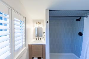 a bathroom with a sink and a shower with a mirror at The Palmetto Inn in Boca Grande