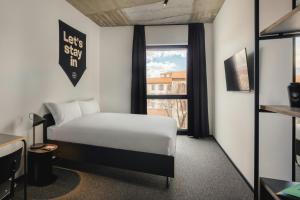a hotel room with a bed and a window at The Social Hub Florence Belfiore in Florence