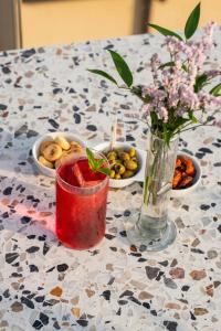 a vase of flowers and a drink on a table at The Social Hub Florence Lavagnini in Florence