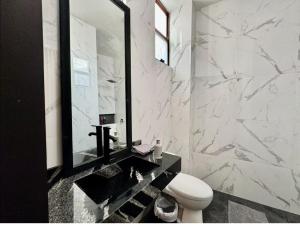 a bathroom with a toilet and a large mirror at Canteira Boutique Aparthotel in Guanajuato