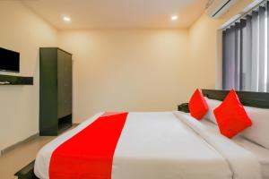 a bedroom with a large bed with red pillows at SPOT ON Pnd Complex in Hyderabad