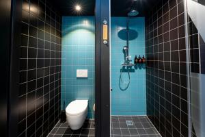 a bathroom with a toilet and a shower with blue tiles at The Social Hub Vienna in Vienna