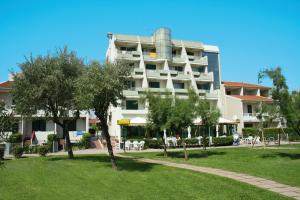 a large white building with a park in front of it at Villaggio Luna Due in Caorle
