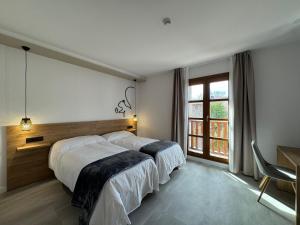 a bedroom with two beds and a large window at Hotel Lupus Silva in Villardeciervos