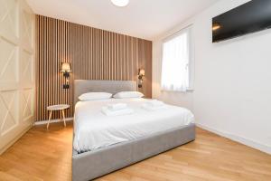a bedroom with a bed and a table and a window at NEW Appartamenti Anna in Sirmione