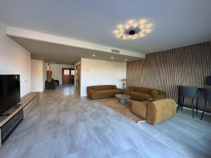 a living room with two couches and a flat screen tv at Hotel Lupus Silva in Villardeciervos