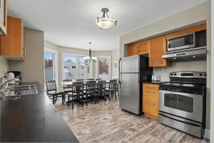 a kitchen with stainless steel appliances and a dining room at Executive-BBQ-Full-Kitchen-Washer-Dryer-Sauna-Backyard-Parking-Air-Conditioning in Blue Mountains