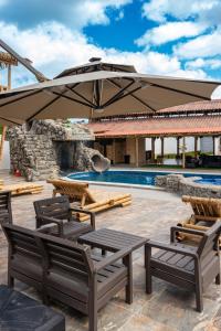 a patio with a table and chairs and an umbrella at Estados Unidos Experience in Ríohacha