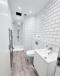 a white bathroom with a toilet and a sink at Central Leith Suite in Edinburgh
