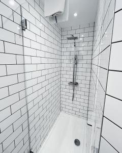 a bathroom with a shower with white tiles at Central Leith Suite in Edinburgh +8 photos