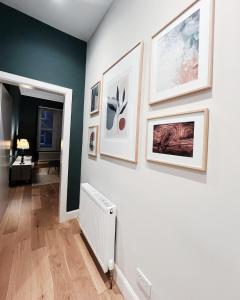 a hallway with pictures on a wall with a radiator at Central Leith Suite in Edinburgh