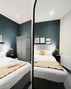 a bedroom with two beds and a mirror at Central Leith Suite in Edinburgh