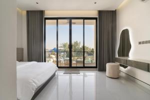 a bedroom with a large bed and a large window at شاليهات وفلل سُبات in Half Moon Bay +16 photos