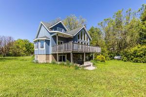 a large blue house on a grassy field at Executive-BBQ-Full-Kitchen-Washer-Dryer-Sauna-Backyard-Parking-Air-Conditioning in Blue Mountains