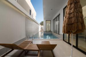 a house with a swimming pool and two chairs at شاليهات وفلل سُبات in Half Moon Bay