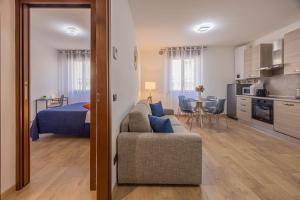 a living room with a couch and a kitchen at PRESTIGE Apartments - Blue Serenity in Verona