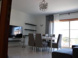 a dining room with a table and chairs and a chandelier at Sesimbra Horizon in Sesimbra