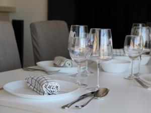 a table with wine glasses and plates and spoons at Sesimbra Horizon in Sesimbra