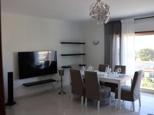 a dining room with a table with chairs and a television at Sesimbra Horizon in Sesimbra +45 photos