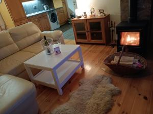 a living room with a couch and a table and a fireplace at Chata Borecké skály in Ktová