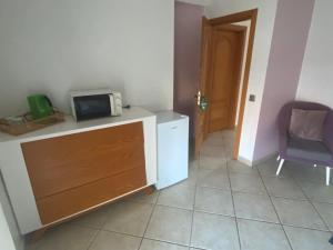 a kitchen with a refrigerator and a microwave on a counter at Lagos Marina Guest House in Lagos