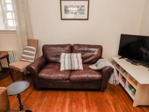 a brown leather couch sitting in a living room at No9 Budle Sands in Bamburgh