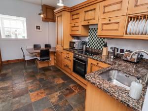 a kitchen with wooden cabinets and a sink and a table at No9 Budle Sands in Bamburgh