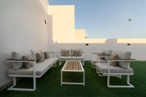 a waiting room with white couches and a table at شاليهات وفلل سُبات in Half Moon Bay