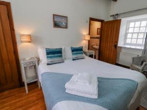 a bedroom with a bed with towels on it at No9 Budle Sands in Bamburgh