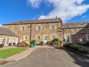 an old stone building with a bench in front of it at No9 Budle Sands in Bamburgh