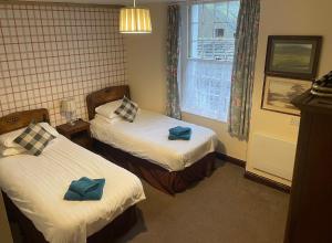 a hotel room with two beds and a window at George and Dragon Dent in Dent
