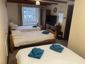 a room with three beds with blue towels on them at George and Dragon Dent in Dent +17 photos