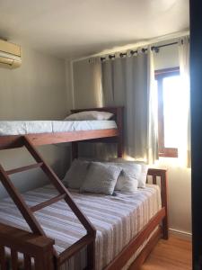 a bedroom with two bunk beds and a window at Chalé Refidim in Gravatá +37 photos