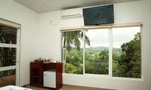 a room with a large window with a television on it at The Villa Rochelle Kandy in Kandy