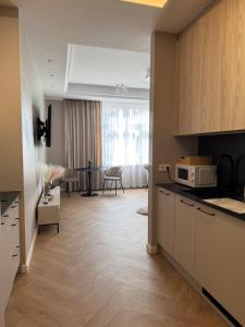 a kitchen with white cabinets and a dining room at Apartamenty Beauty & SPA in Ełk +113 photos