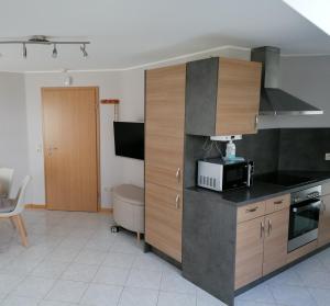 a kitchen with wooden cabinets and a microwave at Die kleine Feine in Olmscheid +5 photos